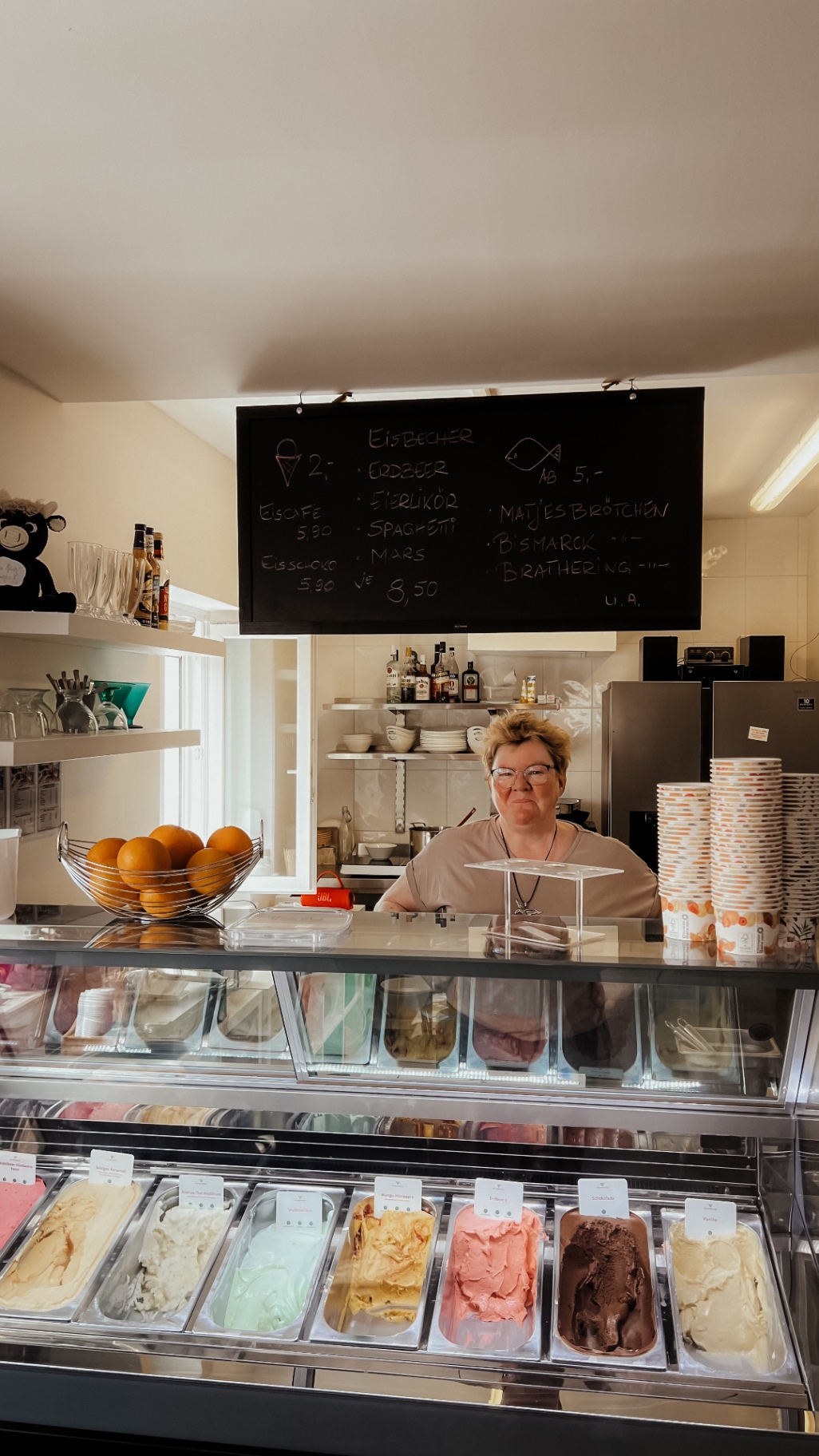 Eistheke mit hausgemachten Sorten und Tafel mit Fischbrötchen-Auswahl